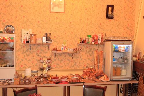 a kitchen with a table and a refrigerator with food at Hotel Bristol in Châlons-en-Champagne