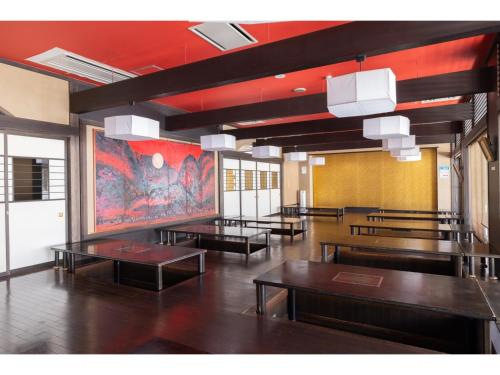 a room with tables and a painting on the wall at TAKAYANAGI JONNOBI VILLAGE - Vacation STAY 90875v in Kashiwazaki