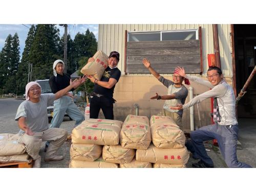 a group of men holding boxes in front of a building at TAKAYANAGI JONNOBI VILLAGE - Vacation STAY 90863v in Kashiwazaki