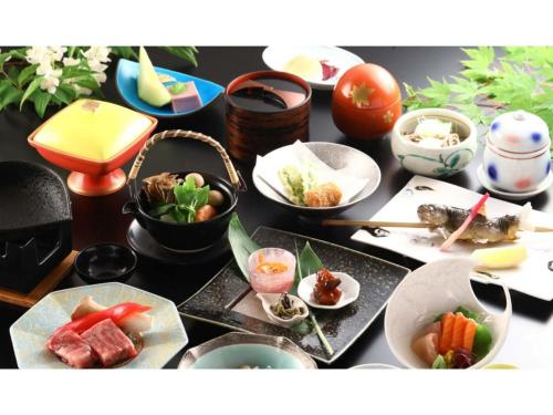 a table topped with bowls and plates of food at Shirafune Grand Hotel - Vacation STAY 85694v in Matsumoto