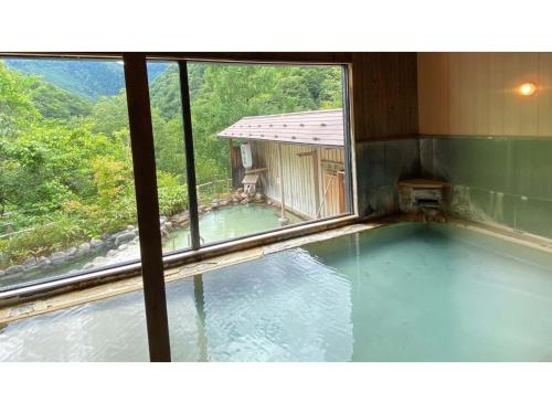 a view of a swimming pool through a window at Shirafune Grand Hotel - Vacation STAY 85694v in Matsumoto