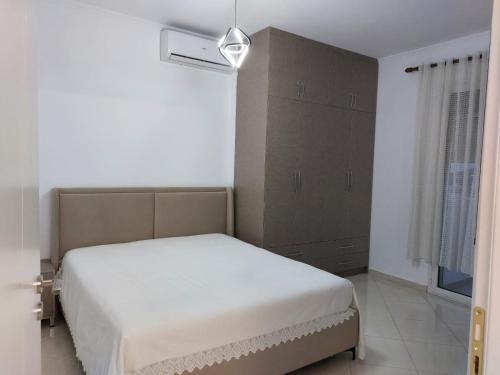 a bedroom with a white bed and a window at 3 rooms apartment in vlora in Vlorë