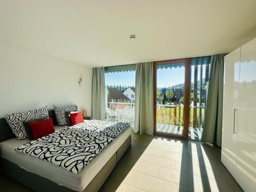 a bedroom with a bed and a large window at Architektenhaus c5 mit Seesicht in Öhningen