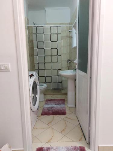 a bathroom with a toilet sink and a washing machine at 3 rooms apartment in vlora in Vlorë