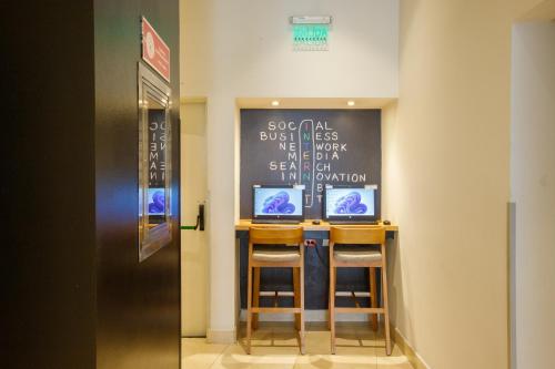 a bar with two stools in a room with a chalkboard at ibis Quito in Quito