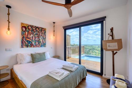 a bedroom with a bed and a large window at Caju Villas Montargil - Villa Pedra Furada in Montargil