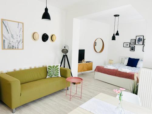 a living room with a couch and a bed at Belvárosi Stúdió Apartman in Kecskemét