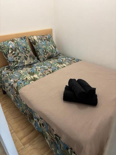 un lit avec deux gants noirs assis sur lui dans l'établissement Studio piscine parking Cannes, à Cannes