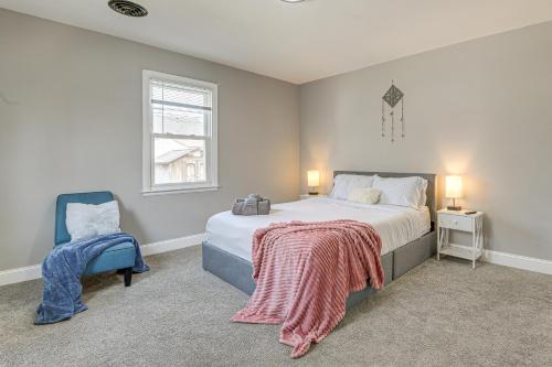 a bedroom with a bed and a blue chair at 4 Mi to Universities Quaint Parkville Apartment! in Parkville