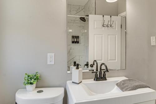 a white bathroom with a sink and a toilet at 4 Mi to Universities Quaint Parkville Apartment! in Parkville
