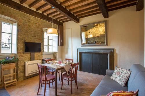 uma sala de estar com uma mesa e cadeiras e um sofá em Casa Zeni em Cortona