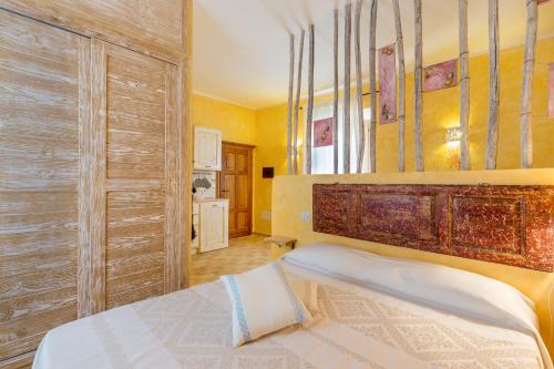 a bedroom with a bed with a wooden headboard at Palazzo Beddoro in San Pantaleo
