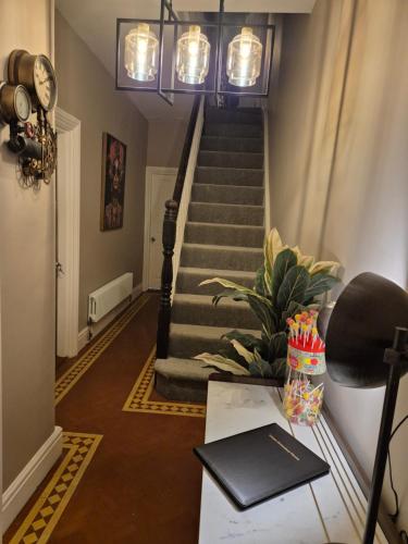 a hallway with a staircase with a desk and a table at Unique Shrewsbury Rooms in Shrewsbury
