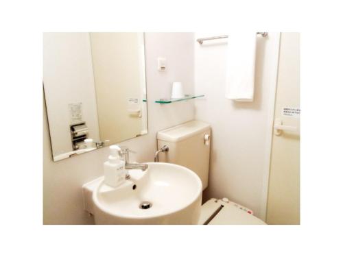 a bathroom with a sink and a toilet and a mirror at Smile Hotel Matsuyama - Vacation STAY 04486v in Matsuyama