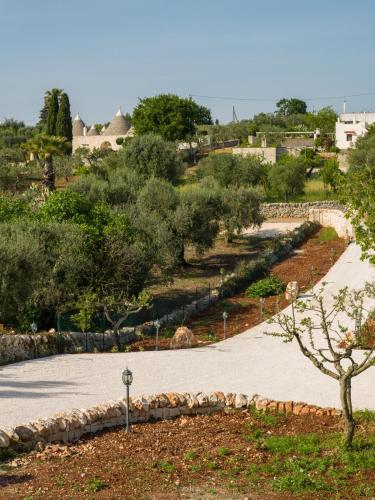 a walkway in a park with trees and buildings at Antichi Saperi - Villa con piscina Cisternino in Cisternino