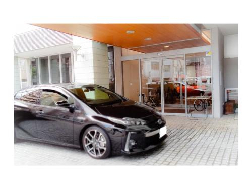 a black car parked in front of a garage at Smile Hotel Matsuyama - Vacation STAY 04497v in Matsuyama