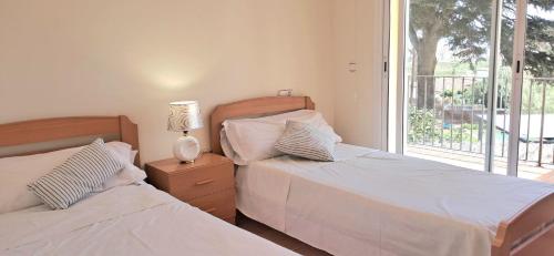 two beds in a bedroom with a balcony at Villa ALVAMAR in Blanes