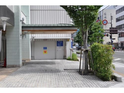 a building with a garage on a city street at Smile Hotel Matsuyama - Vacation STAY 04497v in Matsuyama