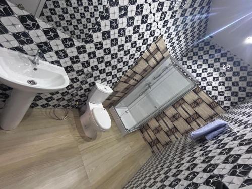 a bathroom with a sink and a toilet and a mirror at SKA Zac Mbao in Rufisque