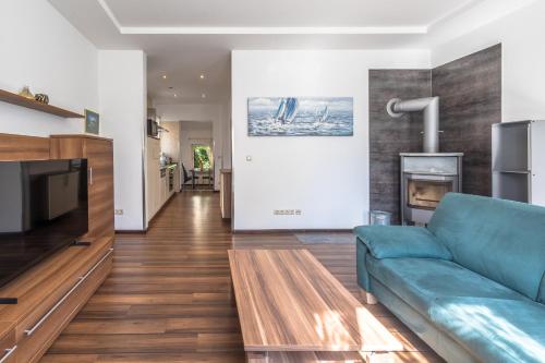 a living room with a blue couch and a fireplace at Ferienwohnung "Kleines Meer" in Waren