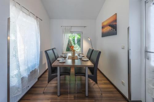 a dining room with a wooden table and chairs at Ferienwohnung "Kleines Meer" in Waren