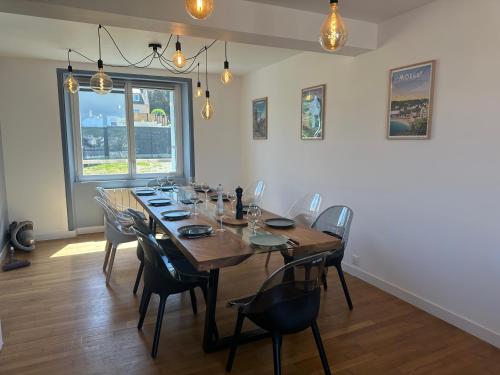 une salle à manger avec une grande table et des chaises en bois dans l'établissement Maison spacieuse Morgat Vue mer imprenable 5 chambres, terrasse XXL, à Crozon