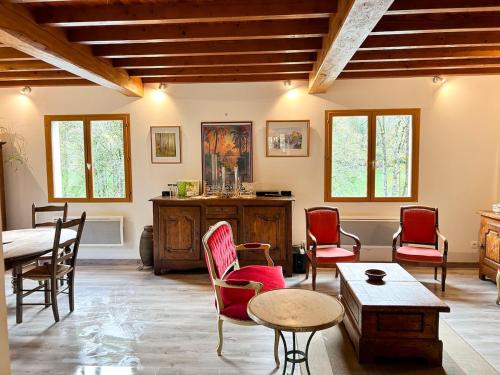 un salon avec des chaises rouges et une table dans l'établissement Grande maison dans la nature, à Le Port