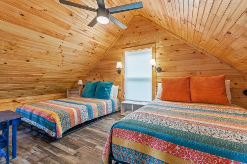 a bedroom with two beds and a ceiling fan at Hemlocks Over Muir in Rogers