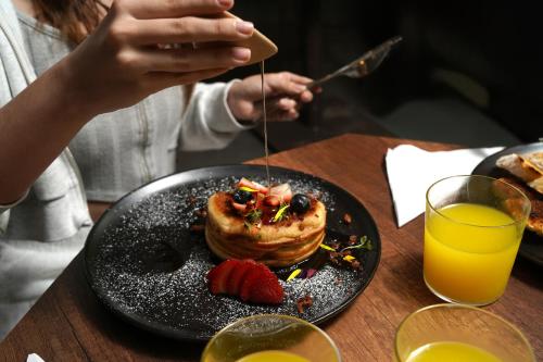 a person is eating a pancake on a table at Hotel Living 35 Suites in Medellín