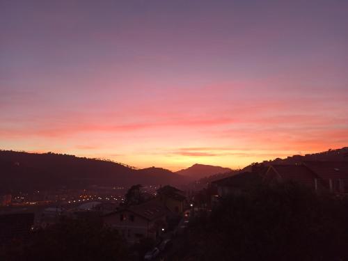 a sunset over a city with houses and mountains at Il Glicine cozy appartamnent, near Sestri Levante between Cinque terre e Portofino in Casarza Ligure