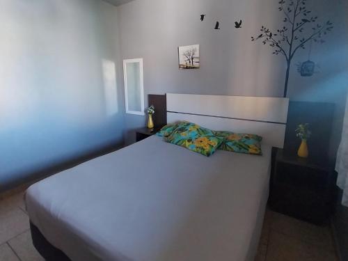 a bedroom with a large white bed with two pillows at Verde Mar Abricó 2 in Rio das Ostras