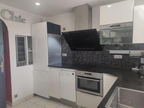 une cuisine avec un évier et une cuisinière four supérieur dans l'établissement Appartement 17, Héliopolis O au village naturiste, au Cap d'Agde