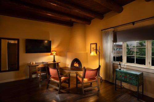 a living room with a table and a fireplace at La Fonda on the Plaza in Santa Fe
