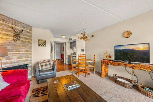a living room with a red couch and a table at Heart of Gatlinburg by Avada Properties in Gatlinburg