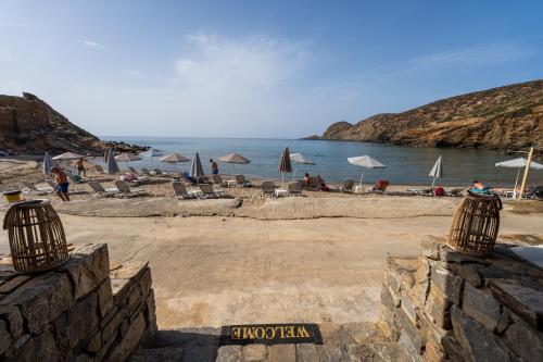 a beach with chairs and umbrellas and the ocean at Stunning Mountain View - Authentic Cretan Village in Metókhion Apisianá