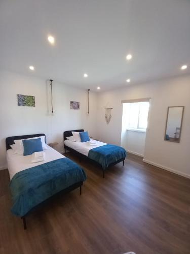two beds in a room with wood floors at Alto do Sossego in Nordeste