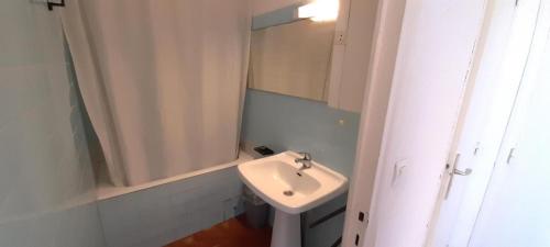 une salle de bain blanche avec un lavabo et une douche dans l'établissement Studio 10, Héliopolis D au village naturiste, au Cap d'Agde