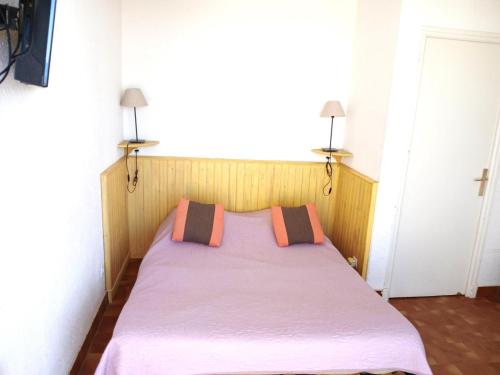 - un lit dans une chambre avec 2 oreillers dans l'établissement Studio 10, Héliopolis D au village naturiste, au Cap d'Agde