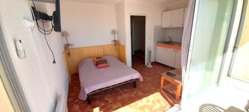 Cette petite chambre comprend un lit et une cuisine. dans l'établissement Studio 10, Héliopolis D au village naturiste, au Cap d'Agde