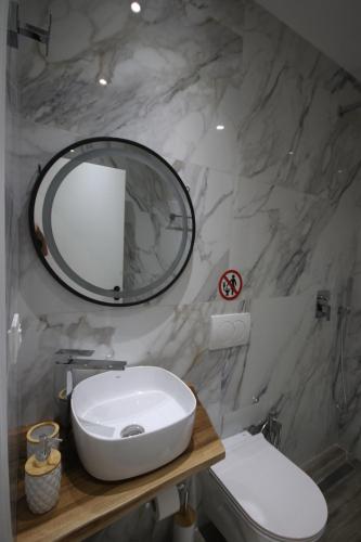 a bathroom with a white sink and a mirror at Klea Rooms in Himare