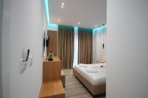 a hotel room with a bed and a television at Klea Rooms in Himare