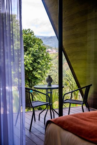 a bedroom with a table and chairs on a balcony at Villa Bosque CR in Turrialba