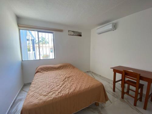 a bedroom with a bed and a desk and a window at Casa entera gran ubicación, aeropuerto ver in Veracruz