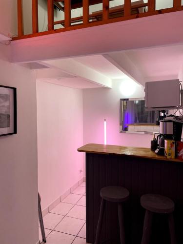 - une cuisine avec un bar et des tabourets dans la chambre dans l'établissement Le Duplex coeur de ville rue de bourgogne, à Orléans