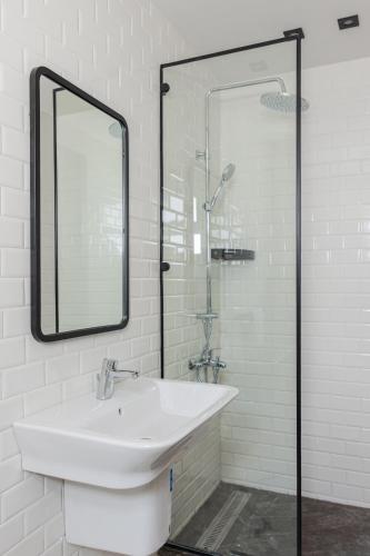 a white bathroom with a sink and a mirror at Elegance Tower in Cairo