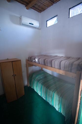 a room with two bunk beds and a cabinet at Cabañas y dormis Zgris in Tinogasta