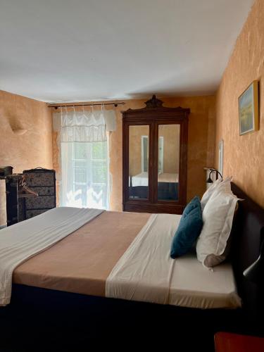 a bedroom with a large bed with blue and white pillows at Le Moulin de Montségur in Montségur-sur-Lauzon