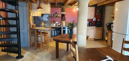 une cuisine avec une table et une cuisine aux murs roses dans l'établissement Residence Pinta Sarlat, à Sarlat-la-Canéda