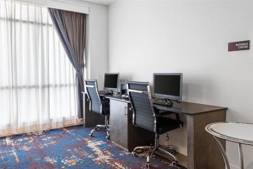 an office with three computer desks with chairs and a window at Best Western Plus New Richmond Inn & Suites in New Richmond