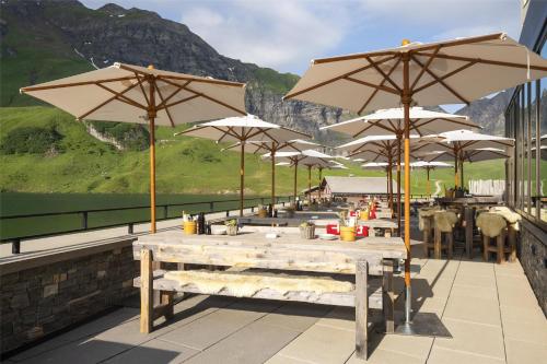 a row of tables with umbrellas on a patio at Frutt Mountain Resort in Frutt